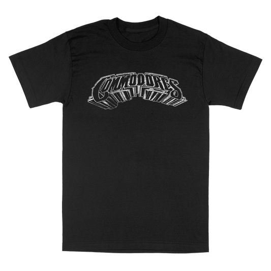 A black short-sleeve crewneck t-shirt featuring a stylized chrome graphic on the chest that reads COMMODORES